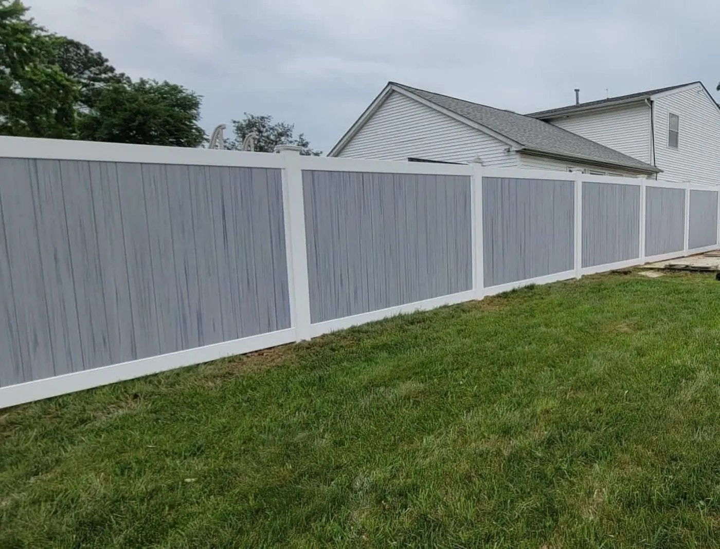 Privacy fence installation along a lawn by Double G Concrete Construction