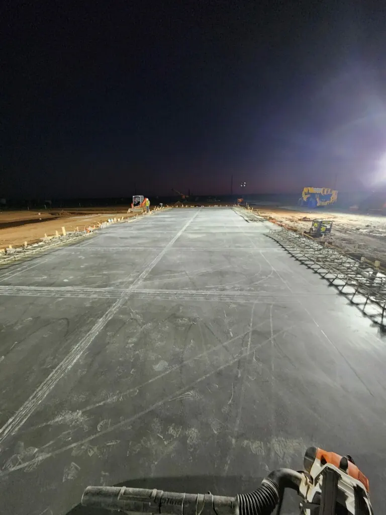 Night-time concrete pour under work lights by Double G Concrete Construction